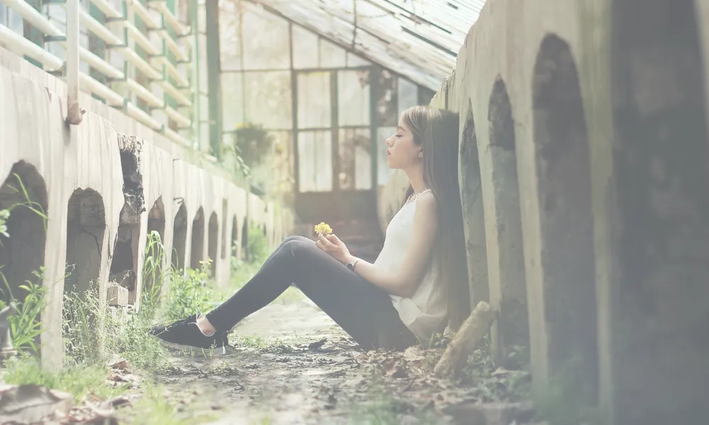 A woman resting in a greenhouse.