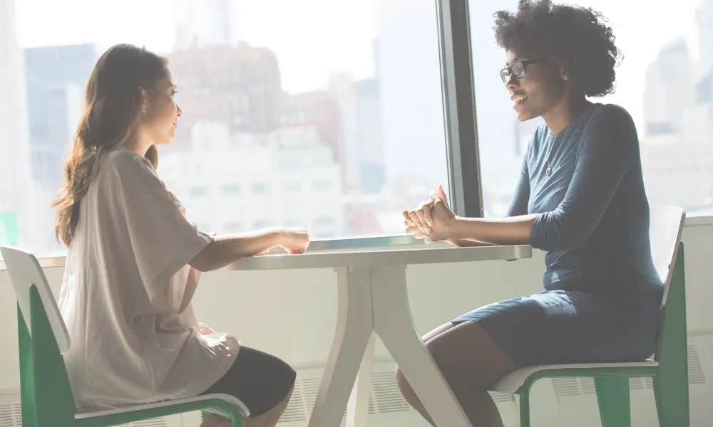 A woman is shown listening to someone else speaking.
